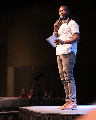 Jey Mbiro speaking on stage
